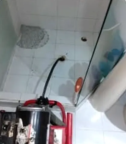 Máquina eléctrica destapando el desagüe de una ducha